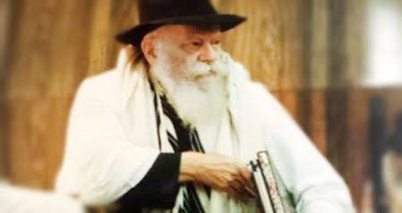 The Rebbe in tallit holding a sefer The Lubavitcher Rebbe wearing a tallit and holding a sefer